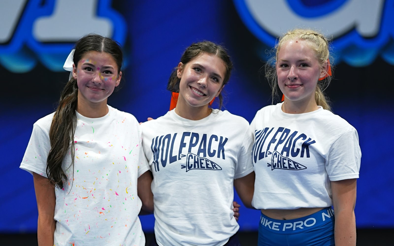 Three cheerleaders posing together at camp